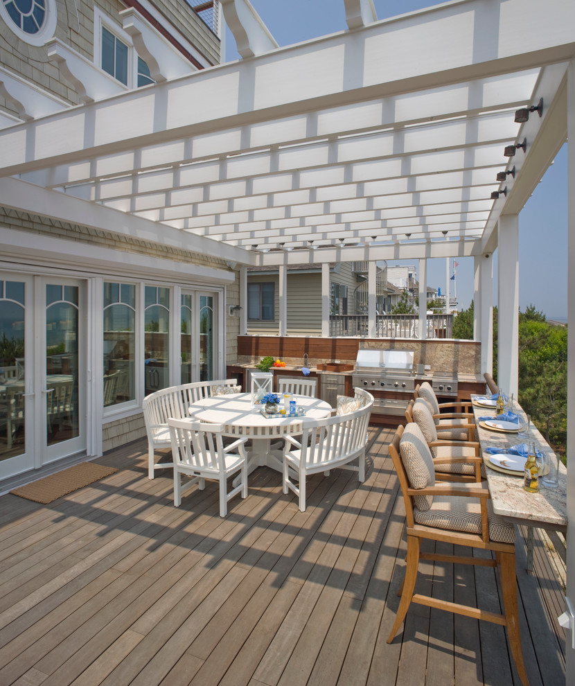 Photo of a beach style deck in DC Metro with a pergola.
