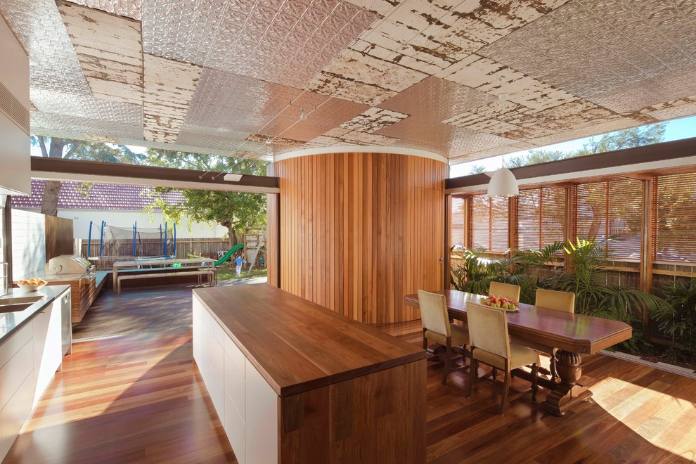 Inspiration for a contemporary kitchen/dining combo in Sydney with white walls and light hardwood floors.