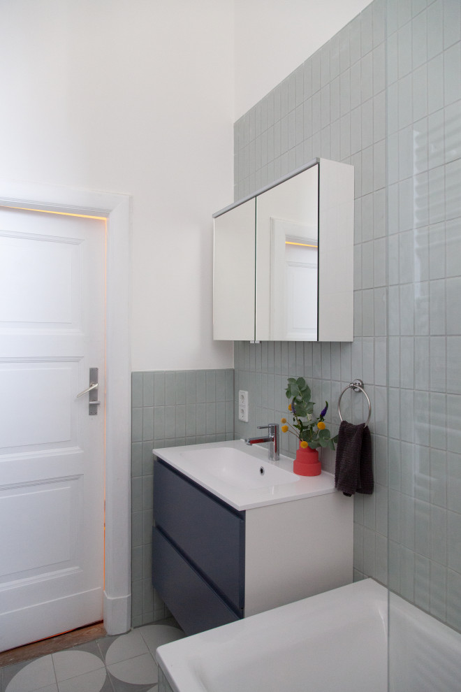 Idées déco pour une salle d'eau longue et étroite et grise et blanche contemporaine de taille moyenne avec un placard avec porte à panneau surélevé, des portes de placard grises, une baignoire posée, un combiné douche/baignoire, WC séparés, un carrelage vert, des carreaux de céramique, un mur blanc, un sol en carrelage de céramique, un lavabo intégré, un plan de toilette en stratifié, un sol gris, aucune cabine, un plan de toilette blanc, meuble simple vasque, meuble-lavabo suspendu et un plafond décaissé.