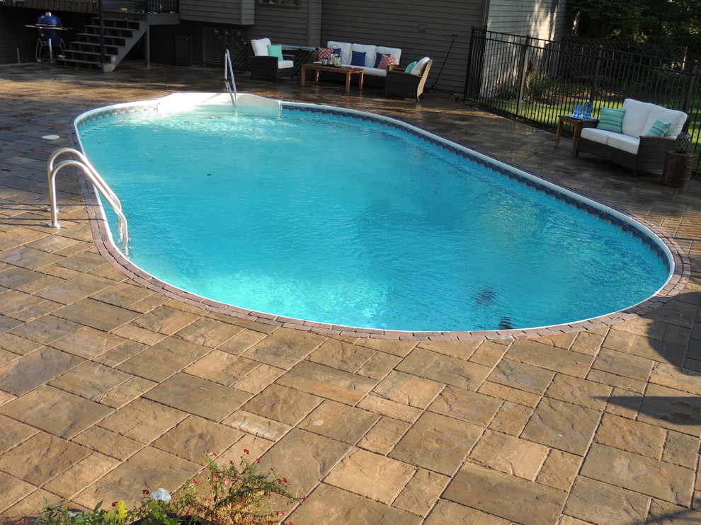 Large traditional backyard round pool in Other.