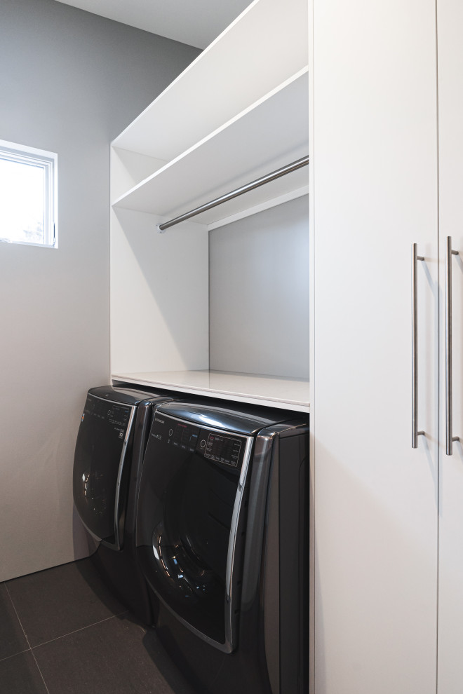 Design ideas for a small modern galley dedicated laundry room in Portland with an undermount sink, flat-panel cabinets, white cabinets, quartz benchtops, white walls, ceramic floors, a side-by-side washer and dryer, grey floor and white benchtop.