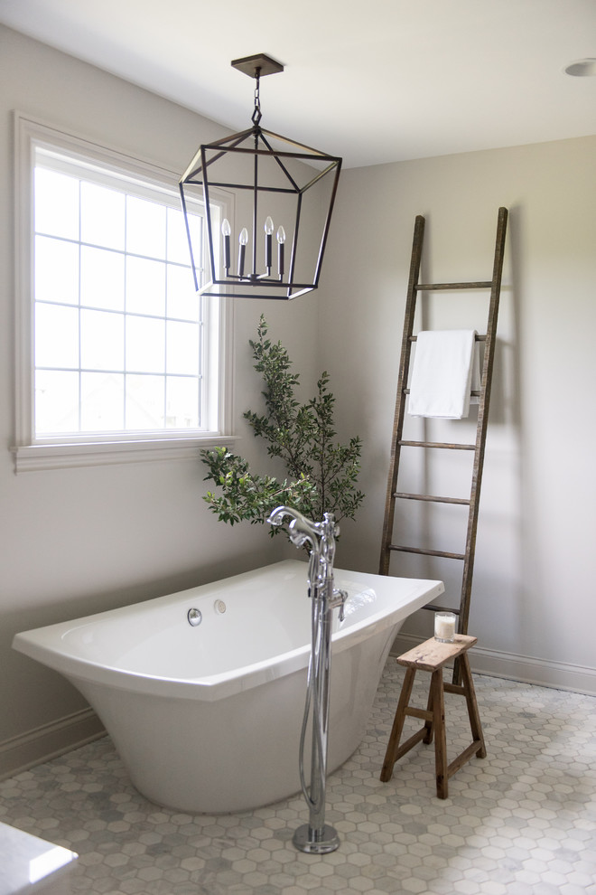 Freestanding bathtub - large transitional master white tile and subway tile marble floor and white floor freestanding bathtub idea in Indianapolis with shaker cabinets, medium tone wood cabinets, a one-piece toilet, white walls, an undermount sink, marble countertops and a hinged shower door
