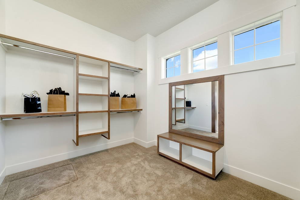 Large country gender-neutral dressing room in Boise with open cabinets, white cabinets, carpet and beige floor.
