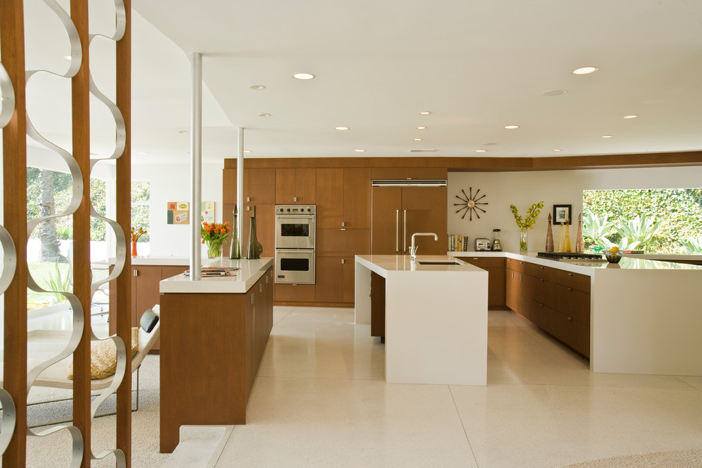 Design ideas for an expansive midcentury u-shaped open plan kitchen in Los Angeles with an undermount sink, flat-panel cabinets, dark wood cabinets, panelled appliances, multiple islands and white floor.