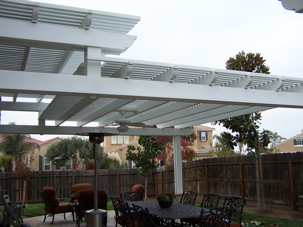 Photo of a mid-sized traditional backyard patio in Other with an outdoor kitchen, concrete slab and a pergola.