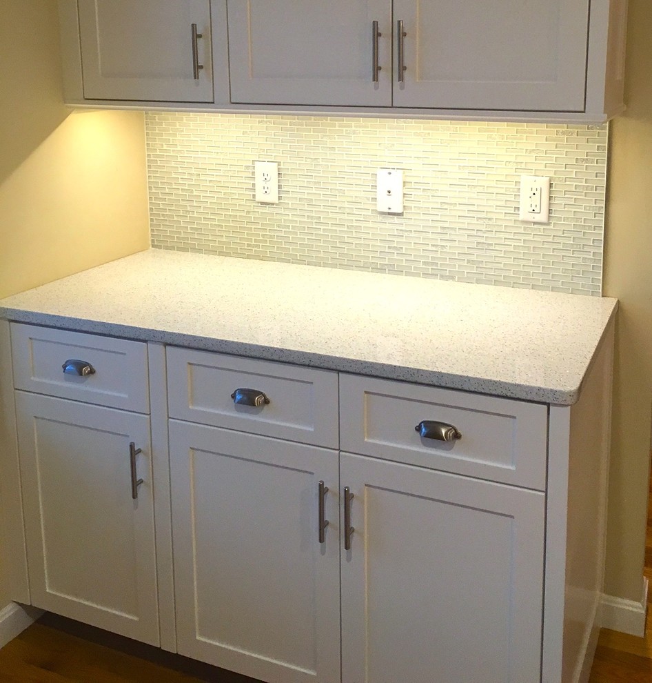 Example of a mid-sized transitional light wood floor eat-in kitchen design in Boston with recessed-panel cabinets, white cabinets, quartz countertops, multicolored backsplash, glass tile backsplash and stainless steel appliances