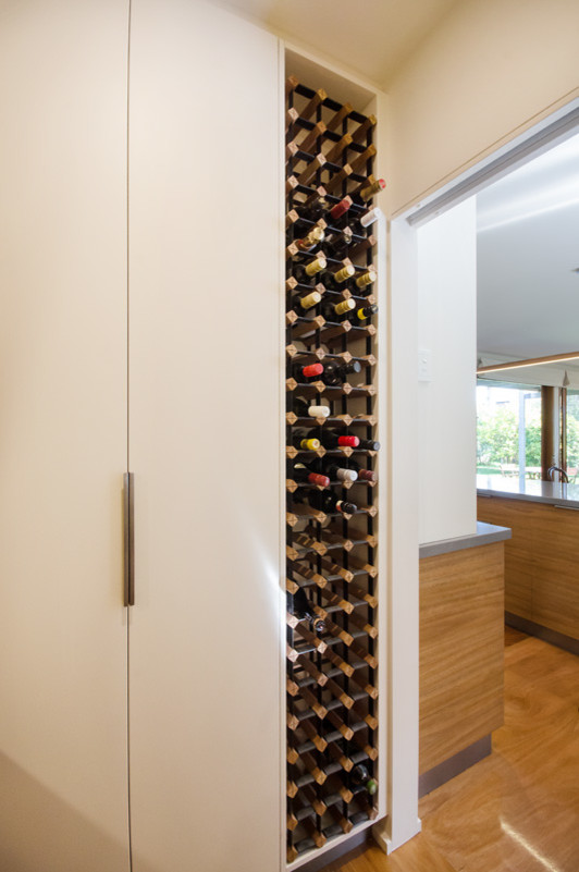 Small contemporary wine cellar in Melbourne with plywood floors.