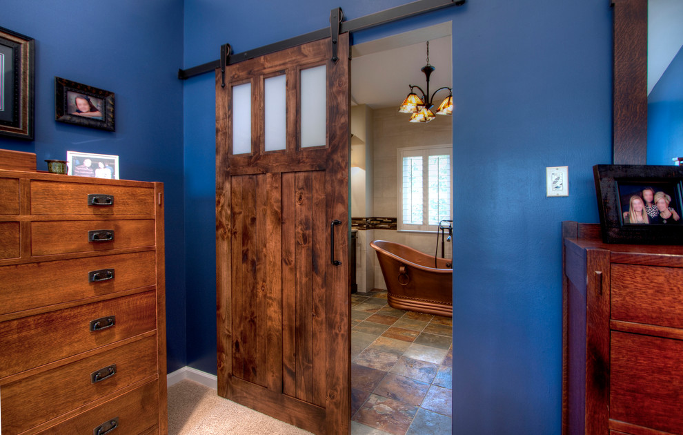 This is an example of an expansive arts and crafts master bathroom in St Louis with shaker cabinets, dark wood cabinets, a freestanding tub, an alcove shower, a one-piece toilet, multi-coloured tile, porcelain tile, beige walls, ceramic floors, an undermount sink and quartzite benchtops.