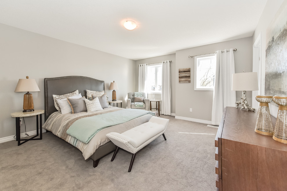 Large transitional master bedroom in Toronto with grey walls, carpet and no fireplace.