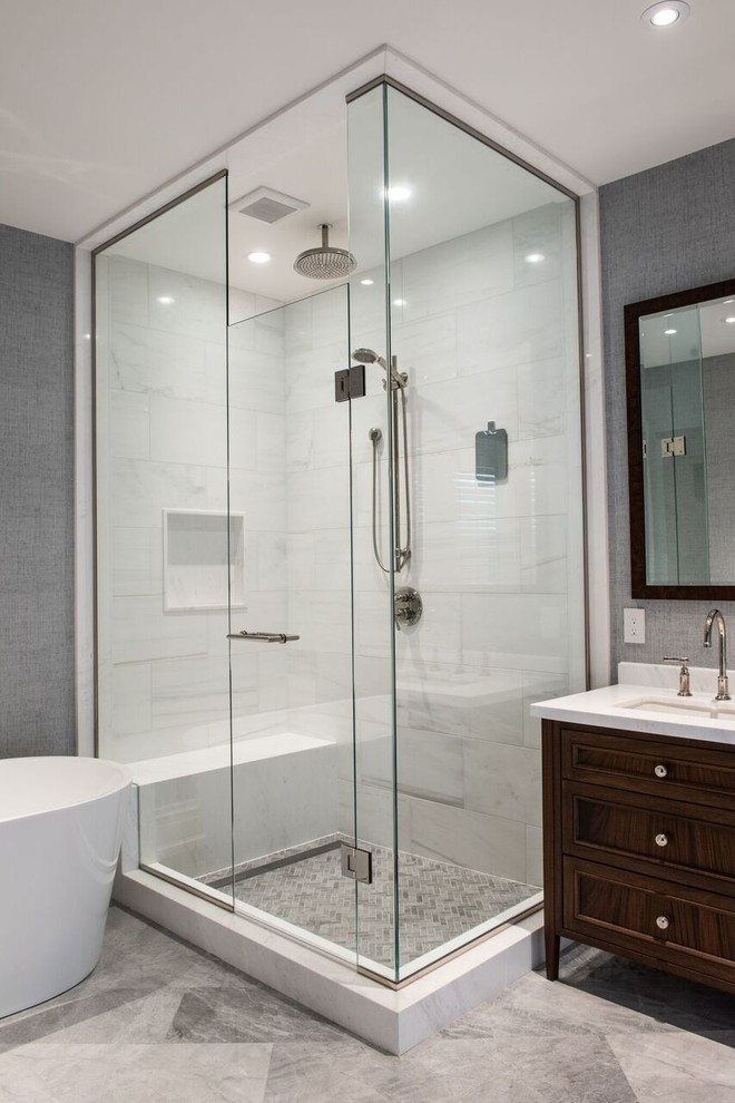 Photo of a mid-sized modern master bathroom in Toronto with shaker cabinets, dark wood cabinets, a freestanding tub, an open shower, a one-piece toilet, gray tile, white tile, stone tile, grey walls, marble floors, an undermount sink and marble benchtops.