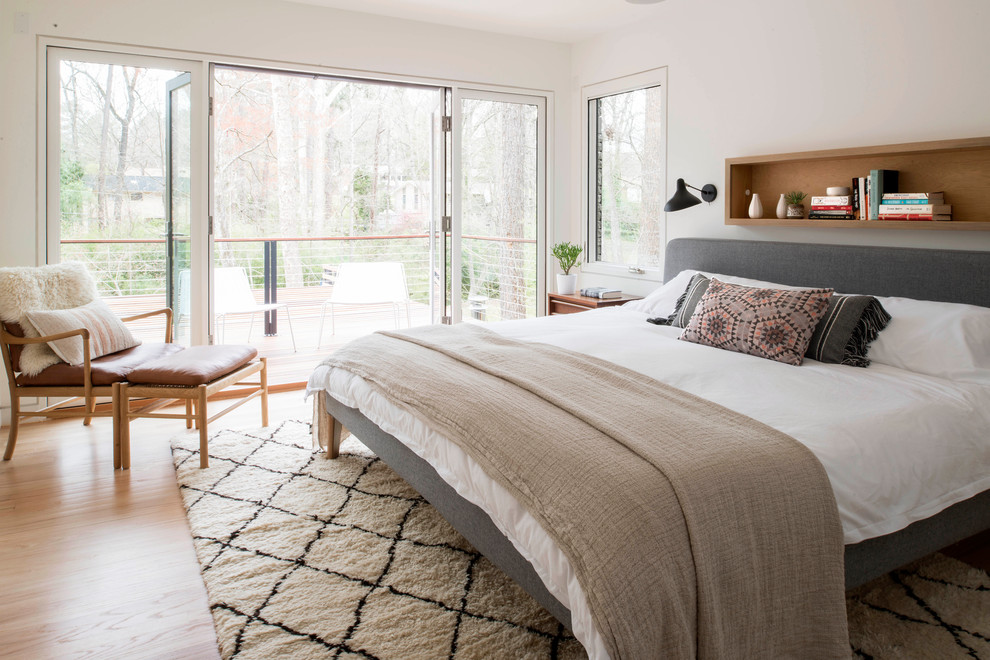 Inspiration for a midcentury master bedroom in Raleigh with white walls and light hardwood floors.