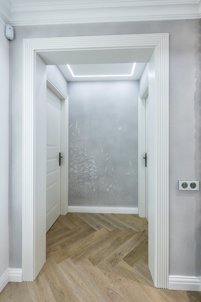 Photo of a large transitional hallway in Moscow with grey walls and medium hardwood floors.