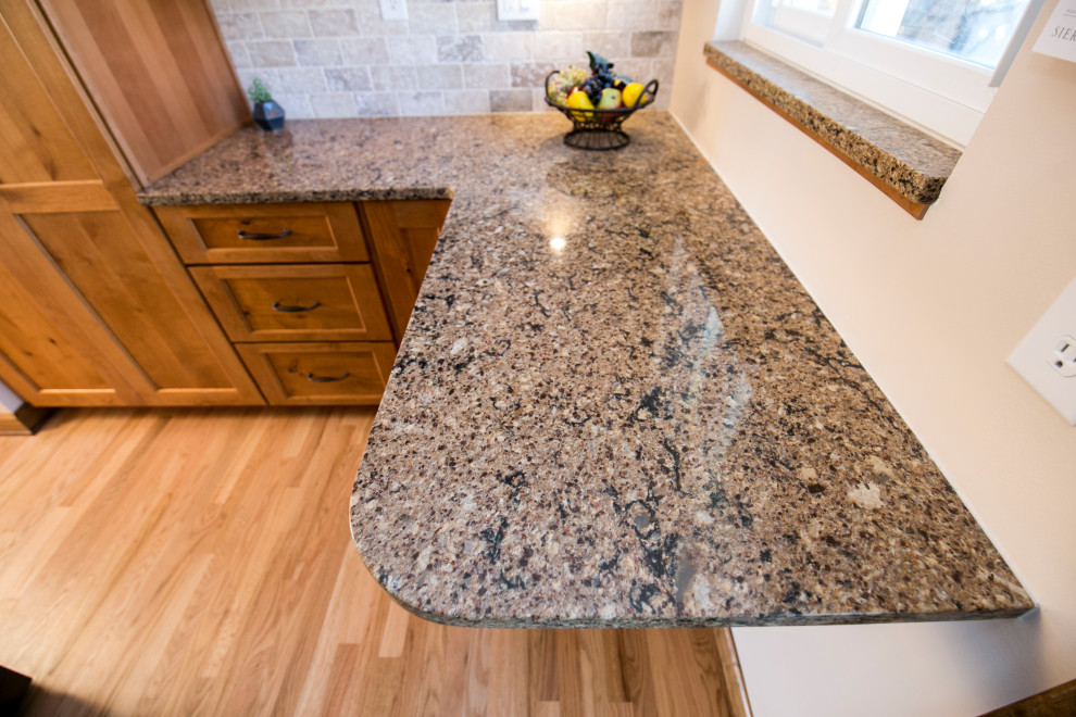 Eat-in kitchen - mid-sized rustic galley medium tone wood floor and brown floor eat-in kitchen idea in Denver with an undermount sink, shaker cabinets, medium tone wood cabinets, quartz countertops, gray backsplash, stone tile backsplash, black appliances, no island and brown countertops