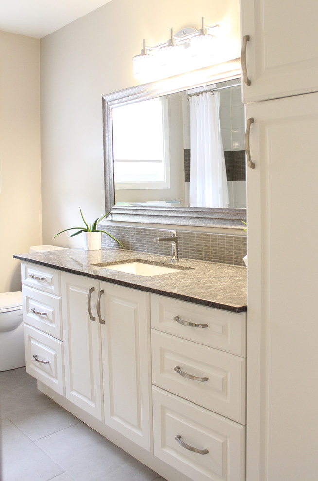 Alcove bathtub - mid-sized transitional 3/4 white tile and porcelain tile porcelain tile and beige floor alcove bathtub idea in Ottawa with raised-panel cabinets, white cabinets, a two-piece toilet, beige walls, an undermount sink and quartz countertops