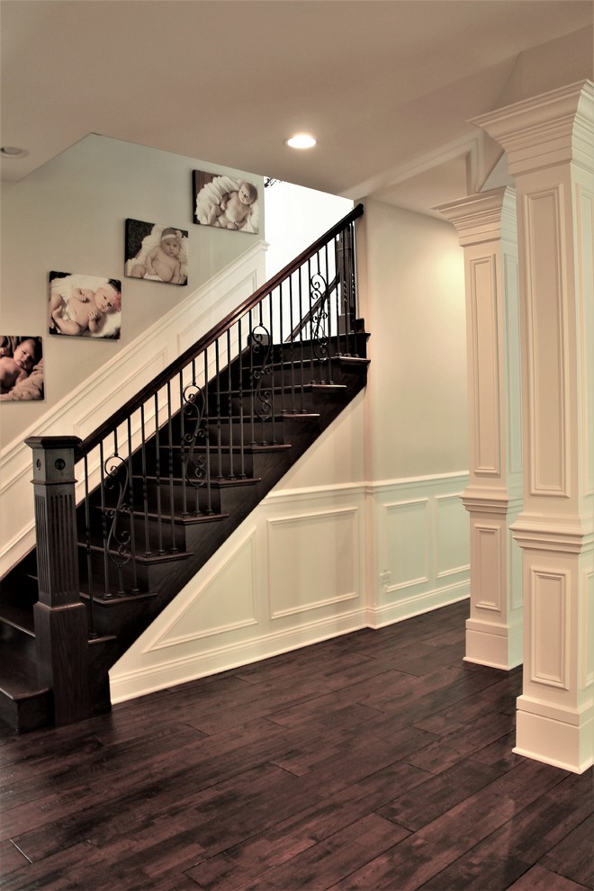 Large traditional wood straight staircase in Chicago with wood risers and metal railing.
