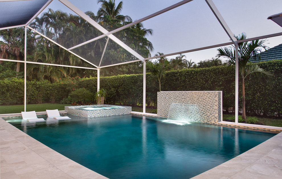 Large modern backyard rectangular pool in Miami with a water feature and tile.