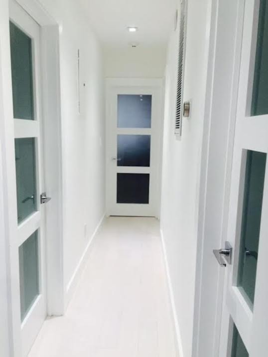 Mid-sized transitional hallway in New York with white walls, porcelain floors and white floor.