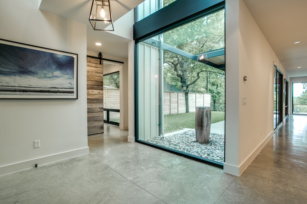 Photo of a modern entryway in Dallas with concrete floors.