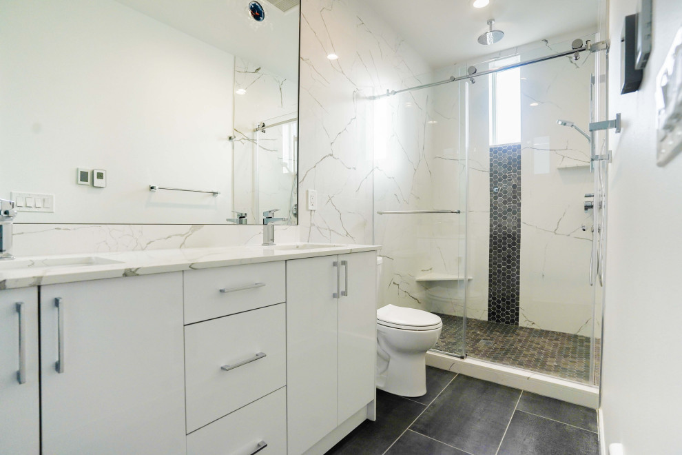 Idéer för mellanstora funkis vitt badrum med dusch, med vita skåp, en toalettstol med hel cisternkåpa, vit kakel, marmorkakel, vita väggar, bänkskiva i kvartsit, dusch med skjutdörr, vinylgolv och brunt golv