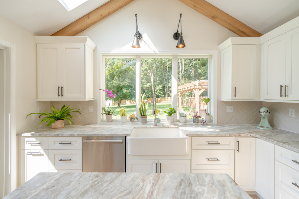 Eat-in kitchen - large transitional l-shaped light wood floor, brown floor and exposed beam eat-in kitchen idea with a farmhouse sink, shaker cabinets, white cabinets, white backsplash, stainless steel appliances, an island, multicolored countertops, marble countertops and ceramic backsplash