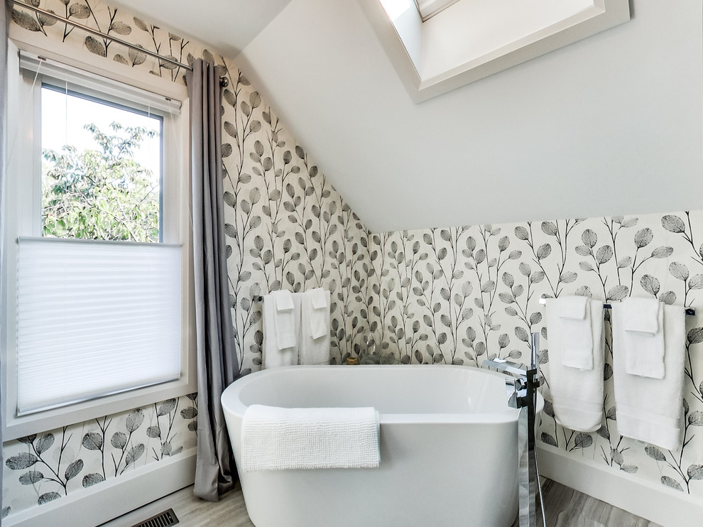 Inspiration for a large transitional master gray tile and limestone tile limestone floor and gray floor freestanding bathtub remodel in Toronto with furniture-like cabinets, gray cabinets, a two-piece toilet, white walls, an undermount sink, quartz countertops and a hinged shower door
