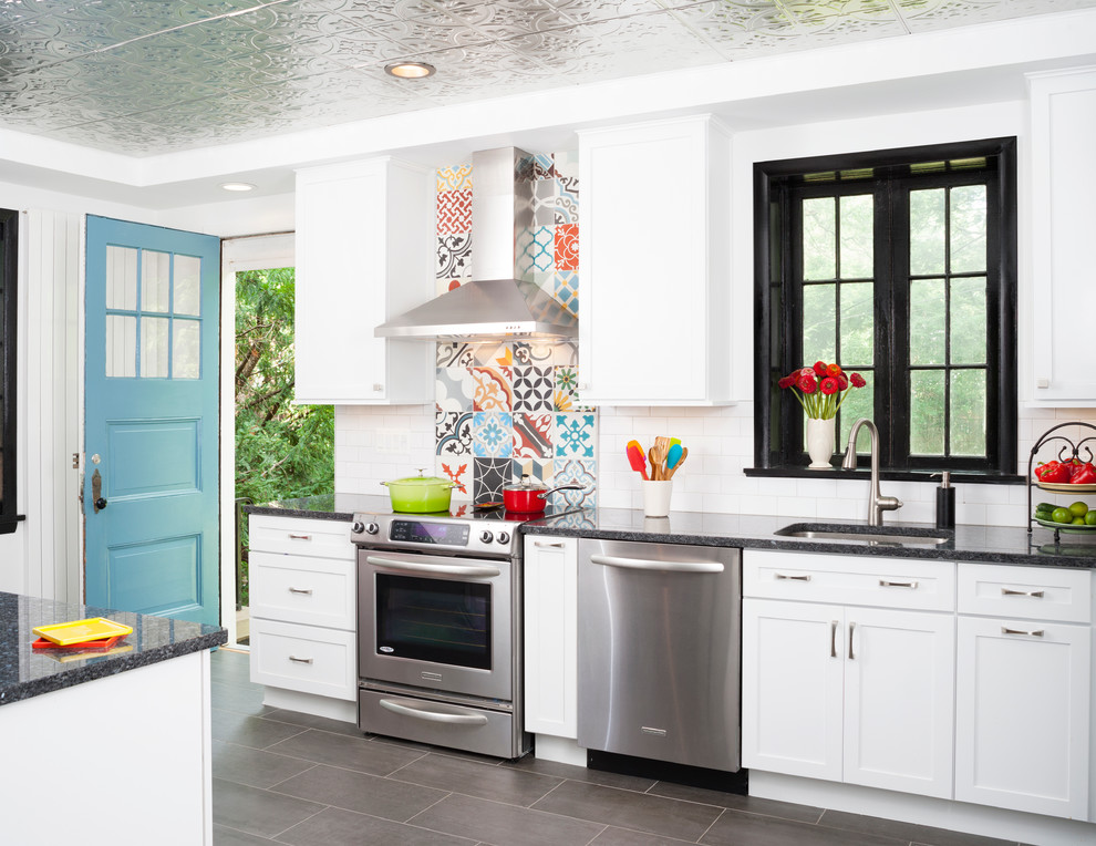 Mid-sized eclectic galley eat-in kitchen in DC Metro with an undermount sink, shaker cabinets, white cabinets, granite benchtops, multi-coloured splashback, cement tile splashback, stainless steel appliances and porcelain floors.