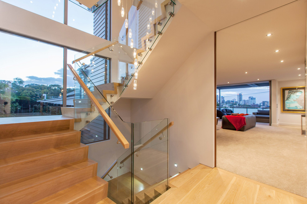 Photo of a large contemporary wood u-shaped staircase in Auckland with wood risers.
