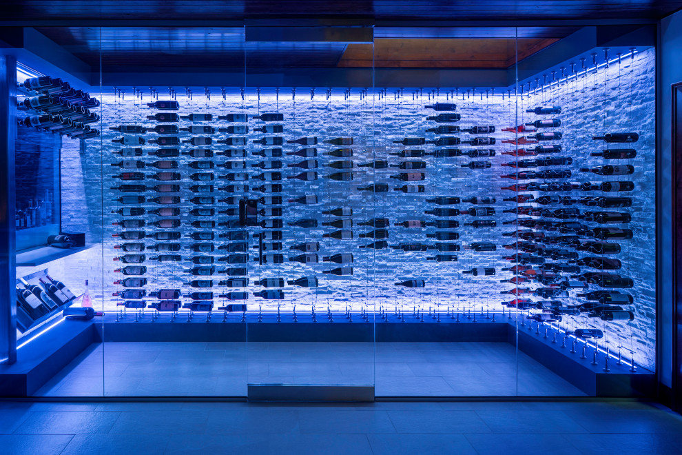 Expansive modern wine cellar in Denver with ceramic floors, display racks and white floor.