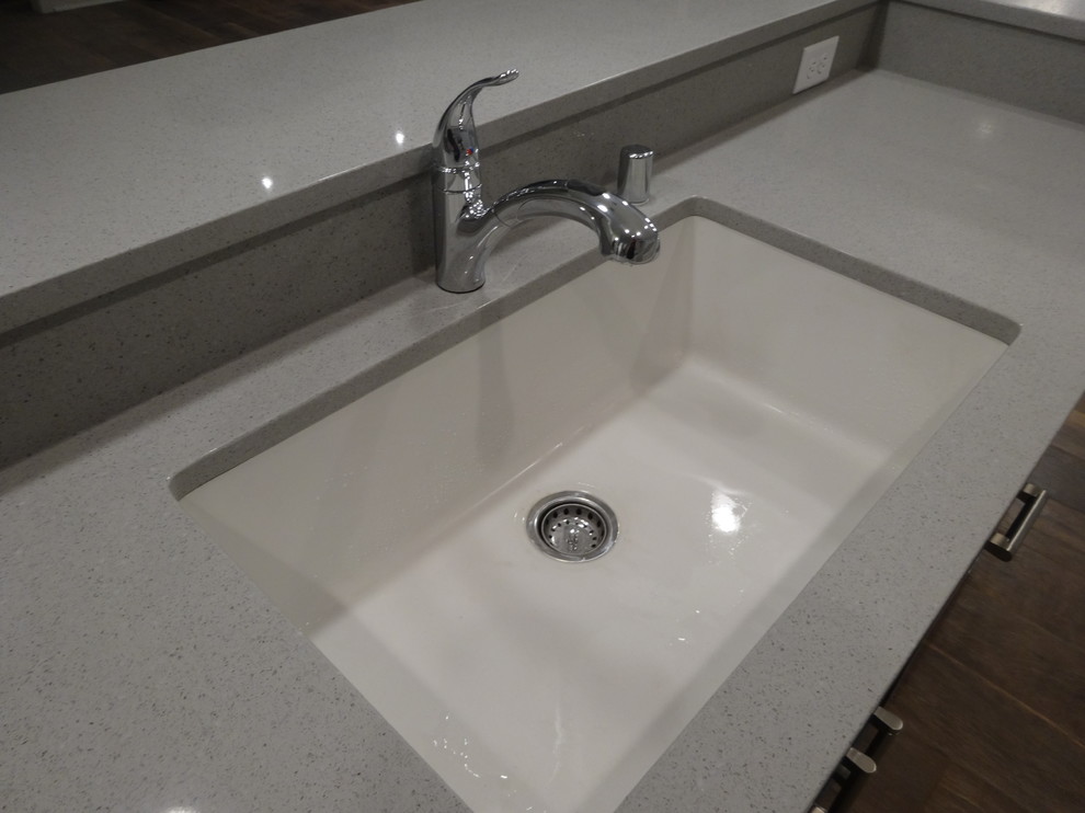 Eat-in kitchen - mid-sized transitional l-shaped porcelain tile eat-in kitchen idea in Milwaukee with a single-bowl sink, recessed-panel cabinets, white cabinets, quartz countertops, gray backsplash, stone slab backsplash, stainless steel appliances and an island
