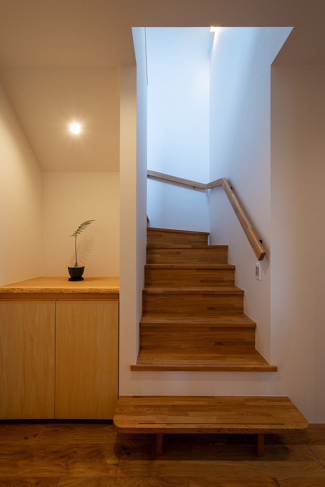 Diseño de escalera en L pequeña con escalones de madera, contrahuellas de madera, barandilla de madera y papel pintado