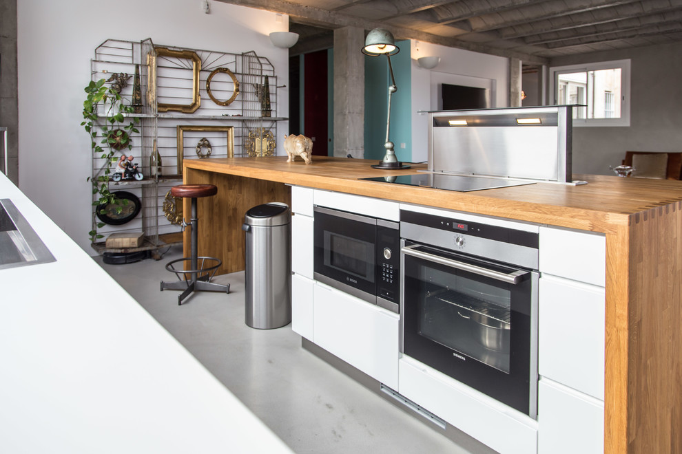 Inspiration for a mid-sized eclectic kitchen in Barcelona with wood benchtops and stainless steel appliances.