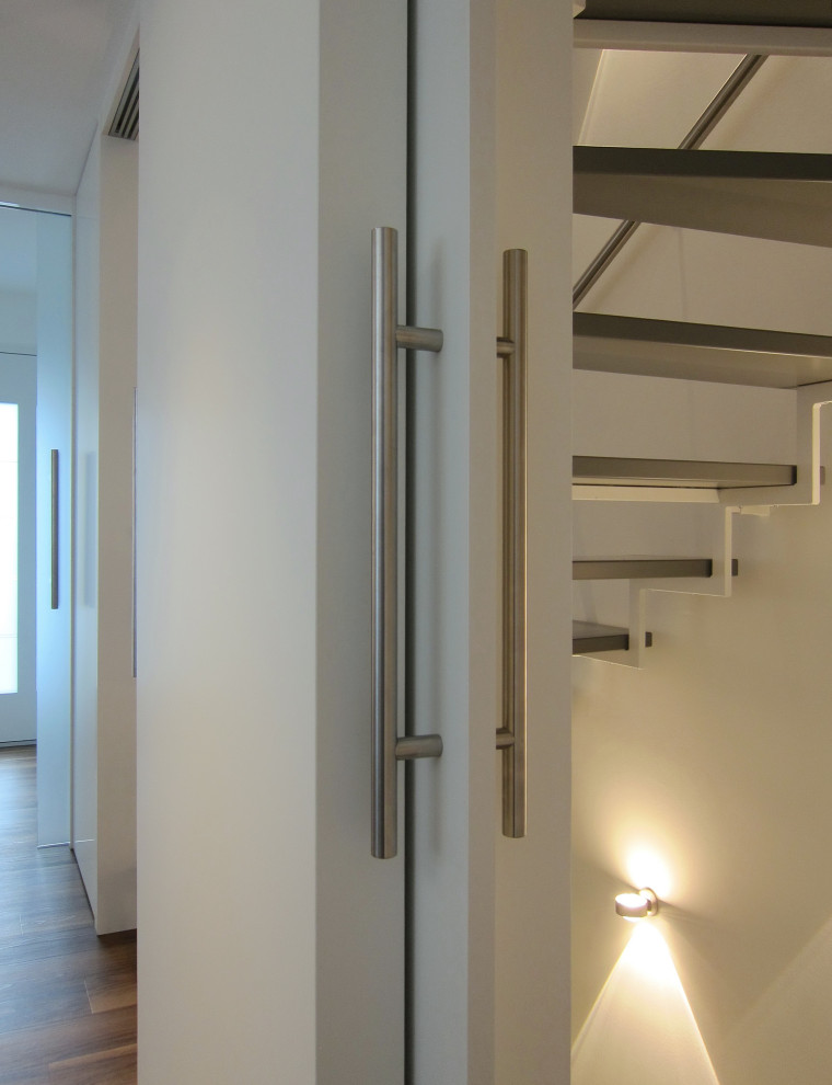 This is an example of a mid-sized contemporary wood u-shaped staircase in Cologne with metal railing.