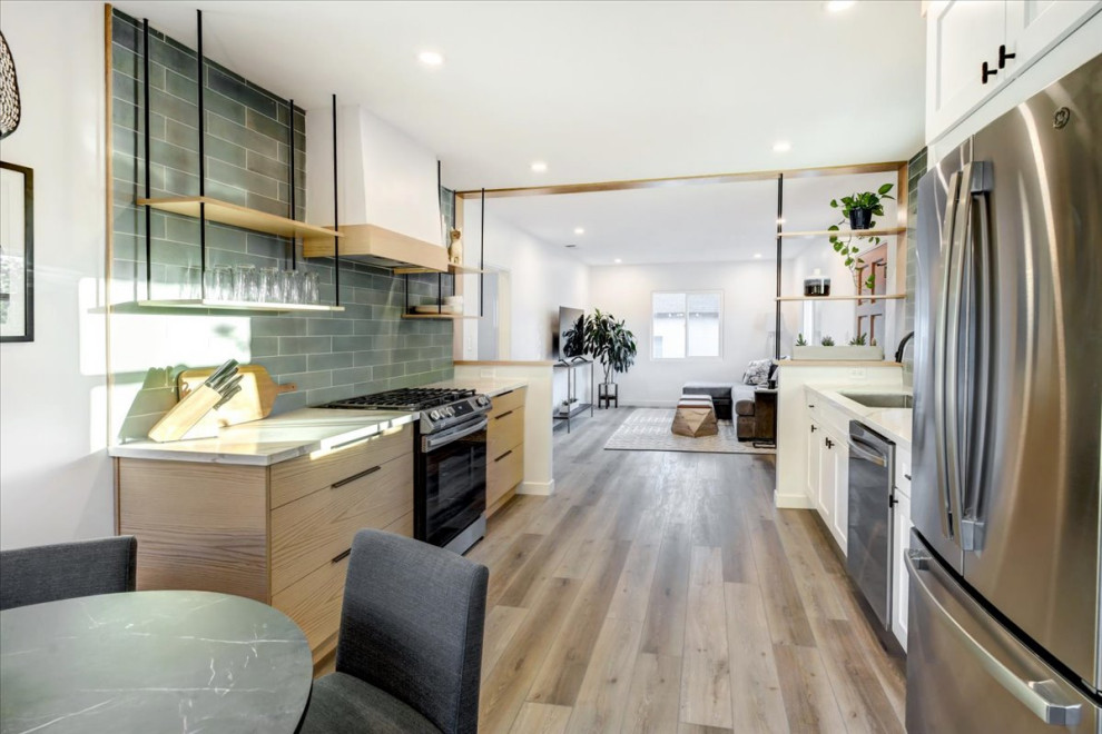 This is an example of a small midcentury galley eat-in kitchen in San Diego with an undermount sink, shaker cabinets, light wood cabinets, quartz benchtops, green splashback, porcelain splashback, stainless steel appliances, medium hardwood floors, no island, beige floor, white benchtop and wood.