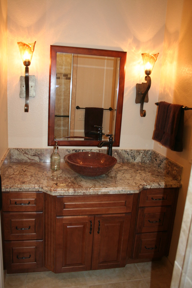 This is an example of a small traditional kids bathroom in San Francisco with a vessel sink, raised-panel cabinets, medium wood cabinets, granite benchtops, a corner shower, a two-piece toilet, beige tile, porcelain tile, beige walls and porcelain floors.