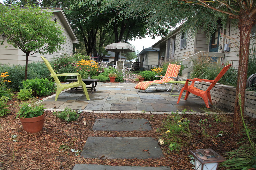 This is an example of a mid-sized traditional front yard full sun formal garden for summer in Minneapolis with a garden path and natural stone pavers.