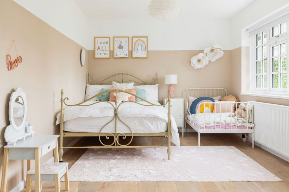 Design ideas for a mid-sized country kids' bedroom for kids 4-10 years old and girls in Surrey with pink walls, light hardwood floors and beige floor.