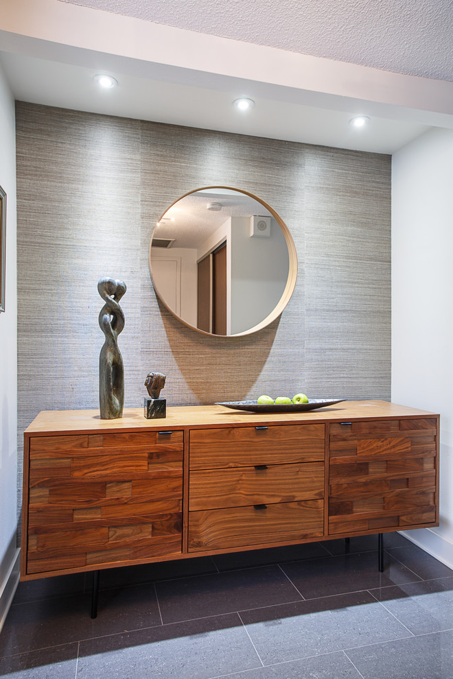 This is an example of a small contemporary foyer in Toronto with white walls, porcelain floors and grey floor.