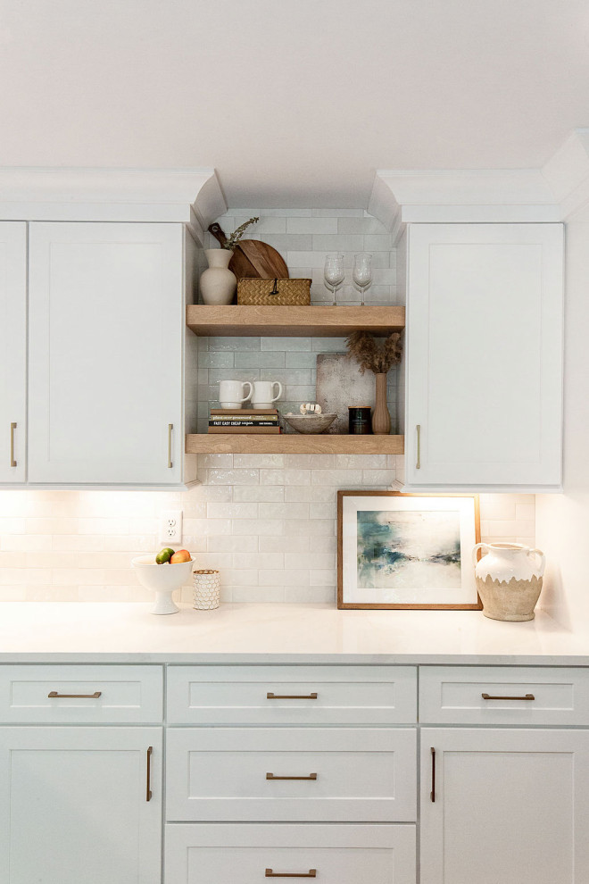 This is an example of a mid-sized contemporary l-shaped eat-in kitchen in Atlanta with a single-bowl sink, shaker cabinets, white cabinets, quartz benchtops, white splashback, subway tile splashback, stainless steel appliances, laminate floors, with island, beige floor and white benchtop.