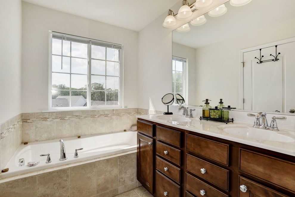 Mid-sized traditional master bathroom in Raleigh with recessed-panel cabinets, dark wood cabinets, a drop-in tub, grey walls, porcelain floors, an undermount sink, beige floor and beige benchtops.