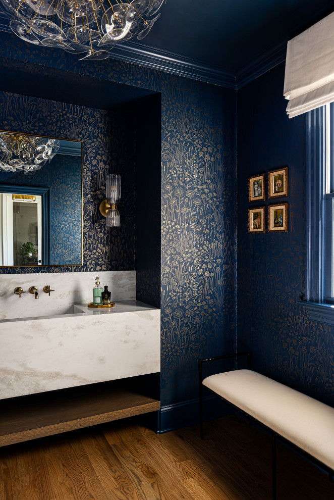 Aménagement d'un WC et toilettes classique avec un mur bleu, parquet foncé, un lavabo intégré, un sol marron, un plan de toilette blanc, meuble-lavabo suspendu et du papier peint.