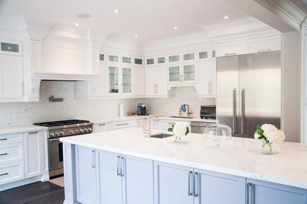 Enclosed kitchen - large transitional l-shaped dark wood floor and brown floor enclosed kitchen idea in Toronto with an undermount sink, shaker cabinets, white cabinets, quartz countertops, white backsplash, marble backsplash, stainless steel appliances, an island and white countertops