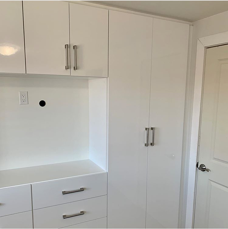 Inspiration for a gender-neutral storage and wardrobe in Toronto with flat-panel cabinets and white cabinets.