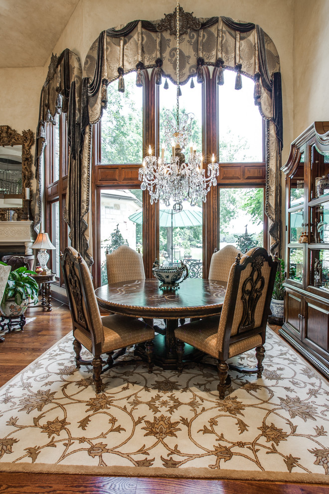 Inspiration for a mid-sized traditional separate dining room in Dallas with medium hardwood floors, a wood fireplace surround, white walls, no fireplace and brown floor.