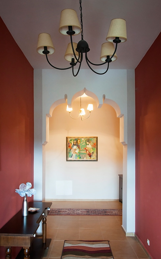 This is an example of a mid-sized asian foyer in Other with brown walls, terra-cotta floors, a double front door and a brown front door.