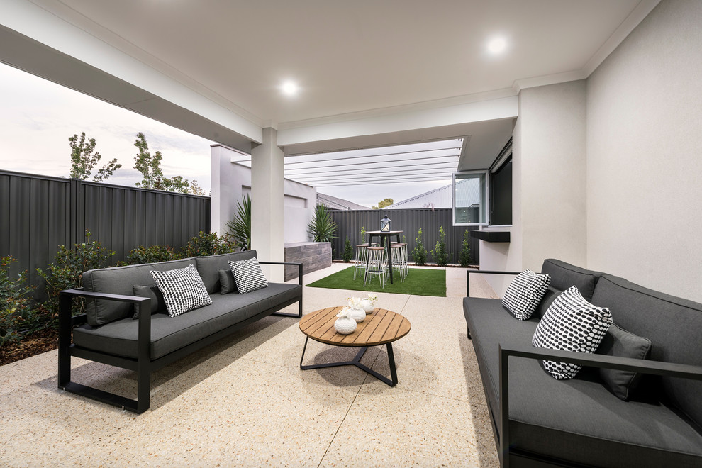 This is an example of a mid-sized modern backyard verandah in Perth with concrete slab and a pergola.