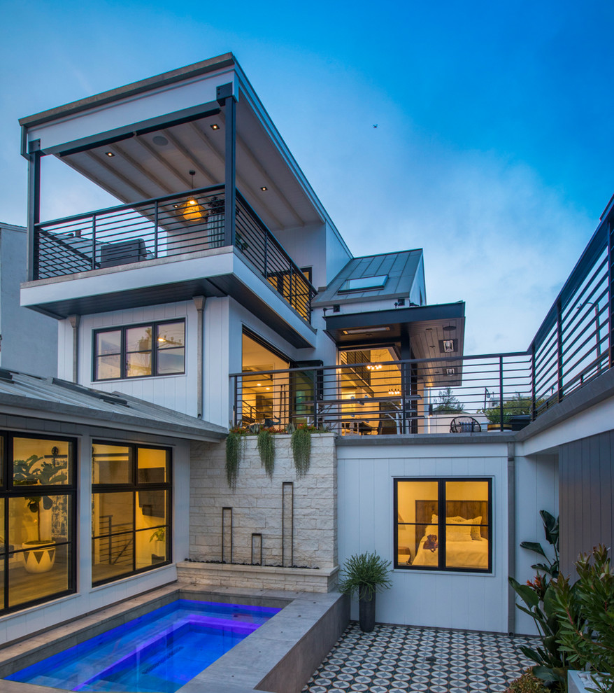 Beach style three-storey white house exterior in Los Angeles.