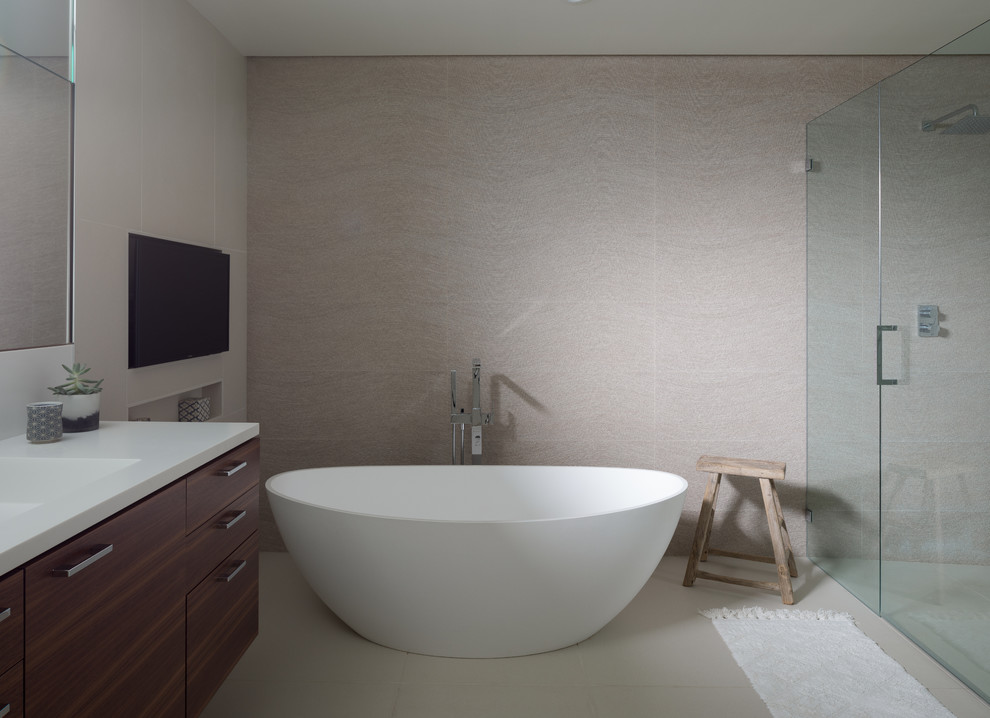Design ideas for a mid-sized modern master bathroom in San Francisco with flat-panel cabinets, a freestanding tub, a curbless shower, a wall-mount toilet, gray tile, porcelain tile, white walls, porcelain floors, an integrated sink, solid surface benchtops, grey floor and a hinged shower door.