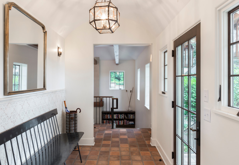 Photo of a large mediterranean entry hall in Portland with white walls, concrete floors, a single front door, a dark wood front door and orange floor.