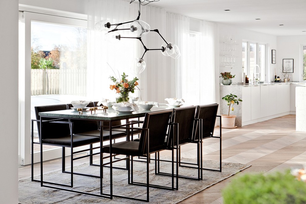 Design ideas for a large contemporary kitchen/dining combo in Malmo with white walls, light hardwood floors and beige floor.