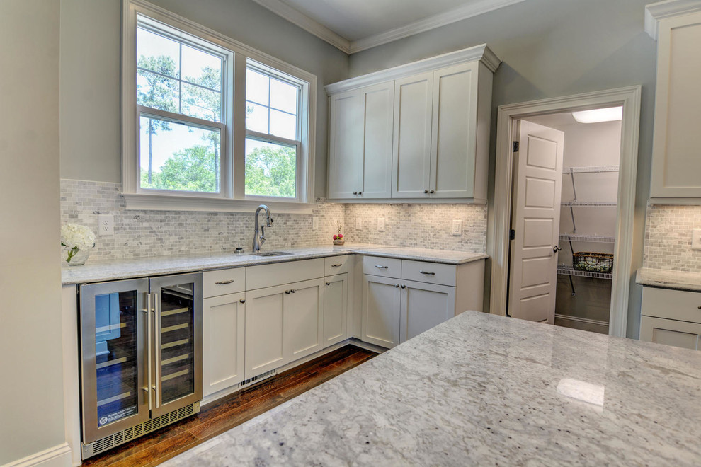 Photo of a transitional open plan kitchen in Wilmington with an undermount sink, shaker cabinets, white cabinets, grey splashback, stone tile splashback, stainless steel appliances, dark hardwood floors, with island and granite benchtops.